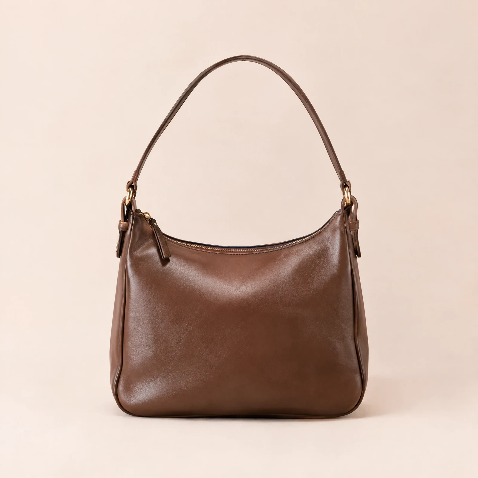 Cocoa brown shoulder bag with zip top upright on a blush background